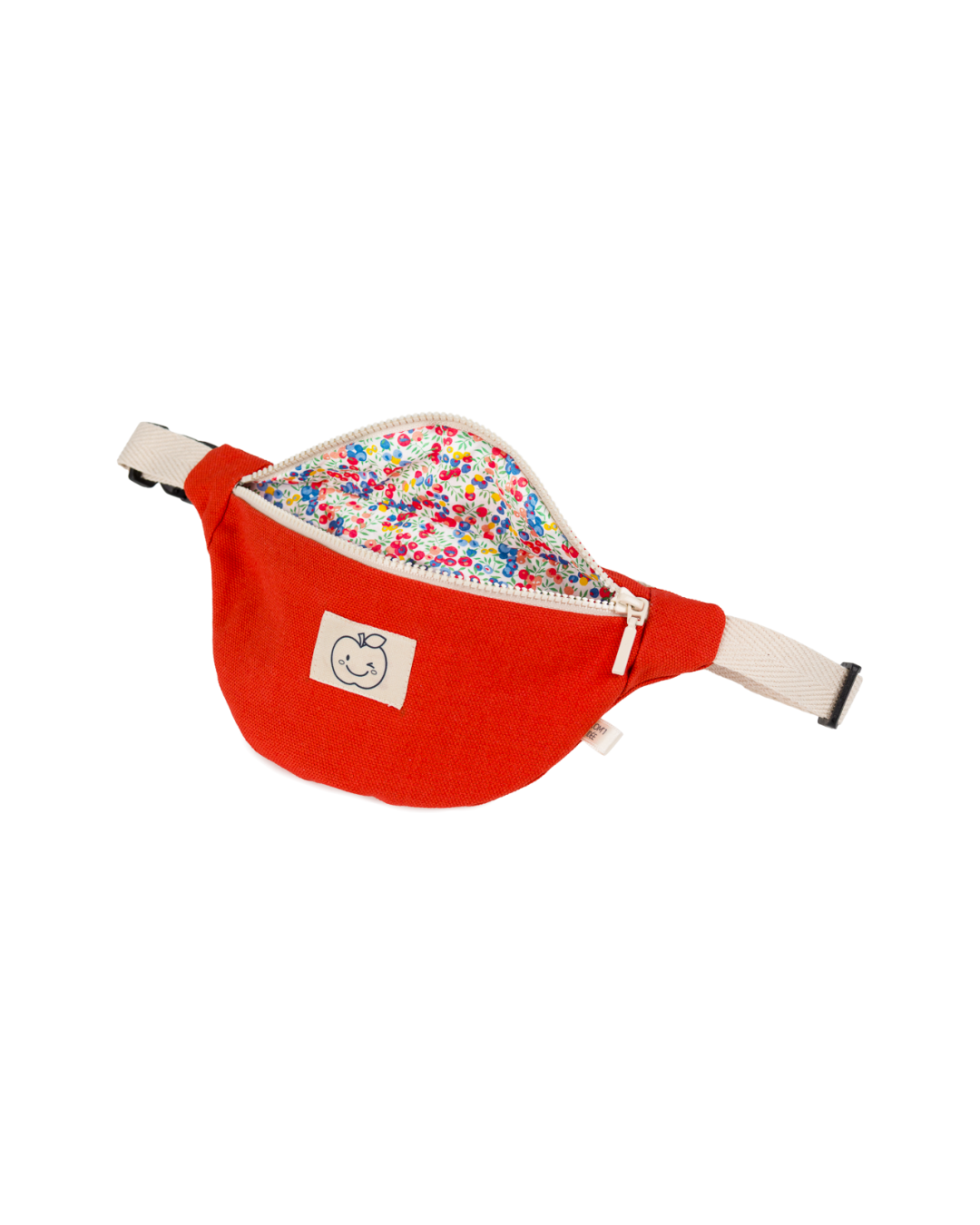 Sac banane enfant Élie rouge ouvert, dévoilant sa doublure Liberty Fabrics à motif floral multicolore.