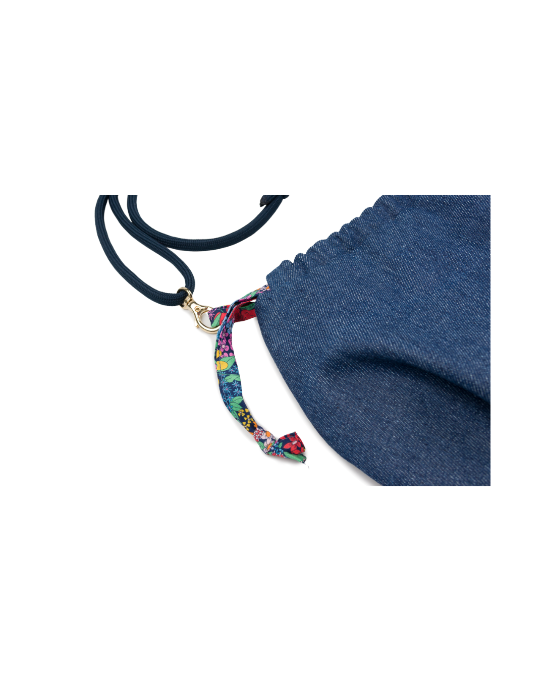 Gros plan sur le mousqueton doré, la bandoulière bleu marine et le lien coulissant en tissu Liberty fleuri du sac bourse Alix.