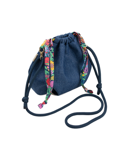 Sac bourse Alix terminé en denim bleu avec liens coulissants et détails en tissu Liberty fleuri multicolore, vue arrière.