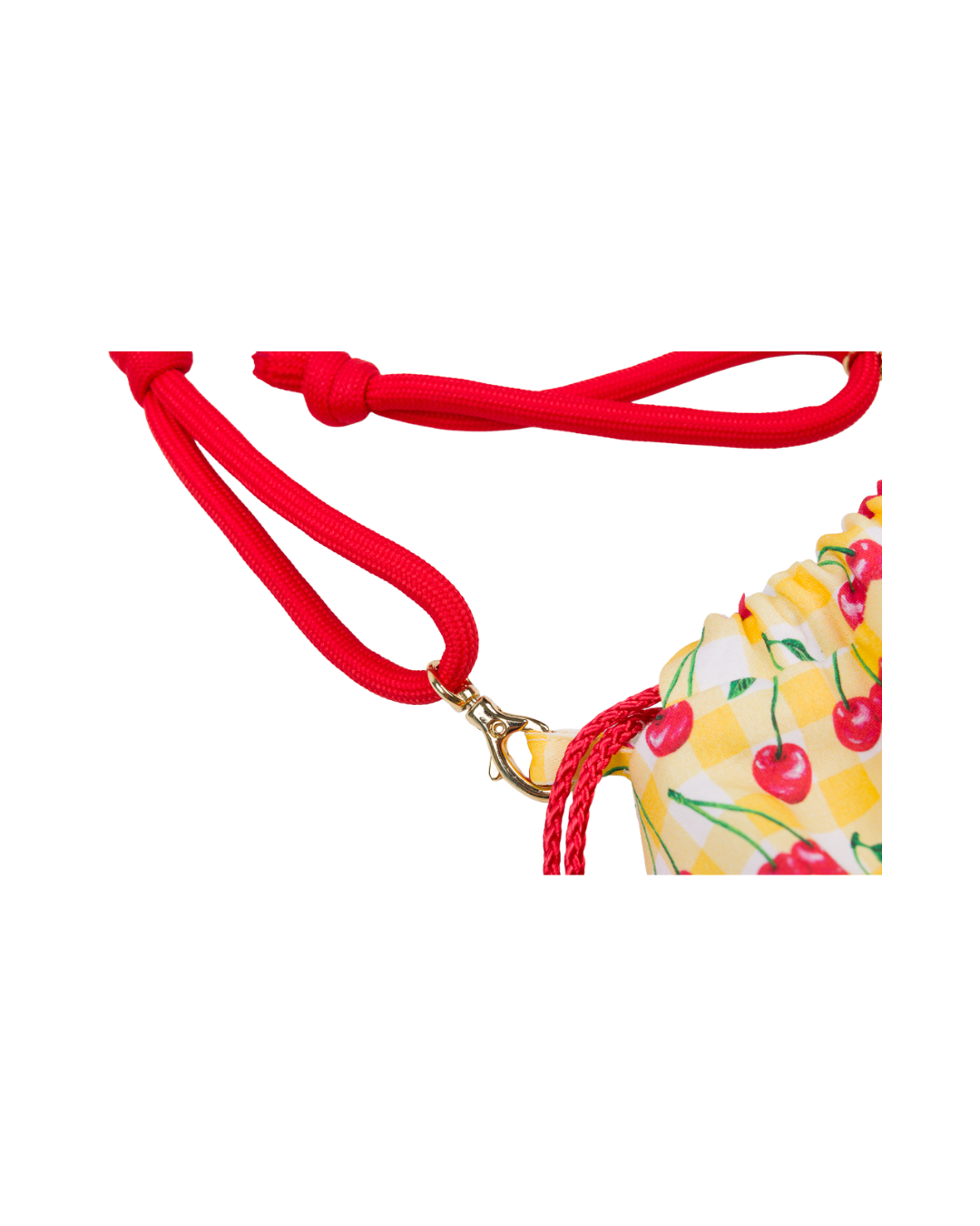 Gros plan sur la bandoulière rouge réglable et le mousqueton doré du sac bourse Telma à motif cerises.