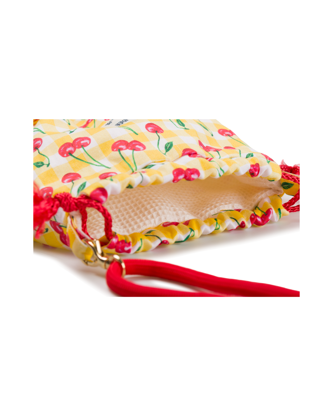 Gros plan sur l’intérieur du sac bourse Telma, montrant la doublure en tissu nid d’abeille et le motif cerises sur fond vichy jaune.